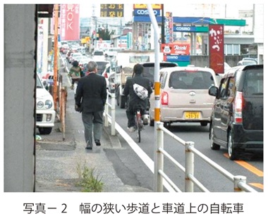 写真2　幅の狭い歩道と車道上の自転車